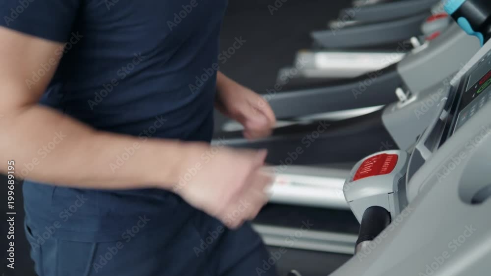 Close up of man finger pushing stop button on treadmill. Safety in gym, end of training Close up of man finger pushing stop button on treadmill. Safety in gym, end of training