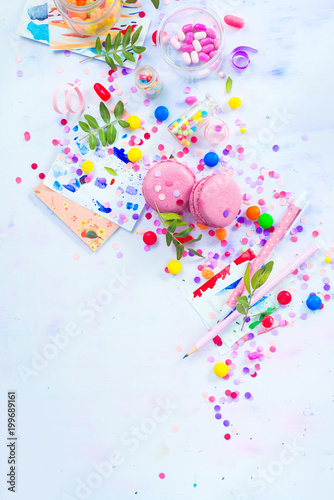 Pink macarons overhead scene with copy space. Colorful celebration flat lay with party supplies  confetti and sweets.