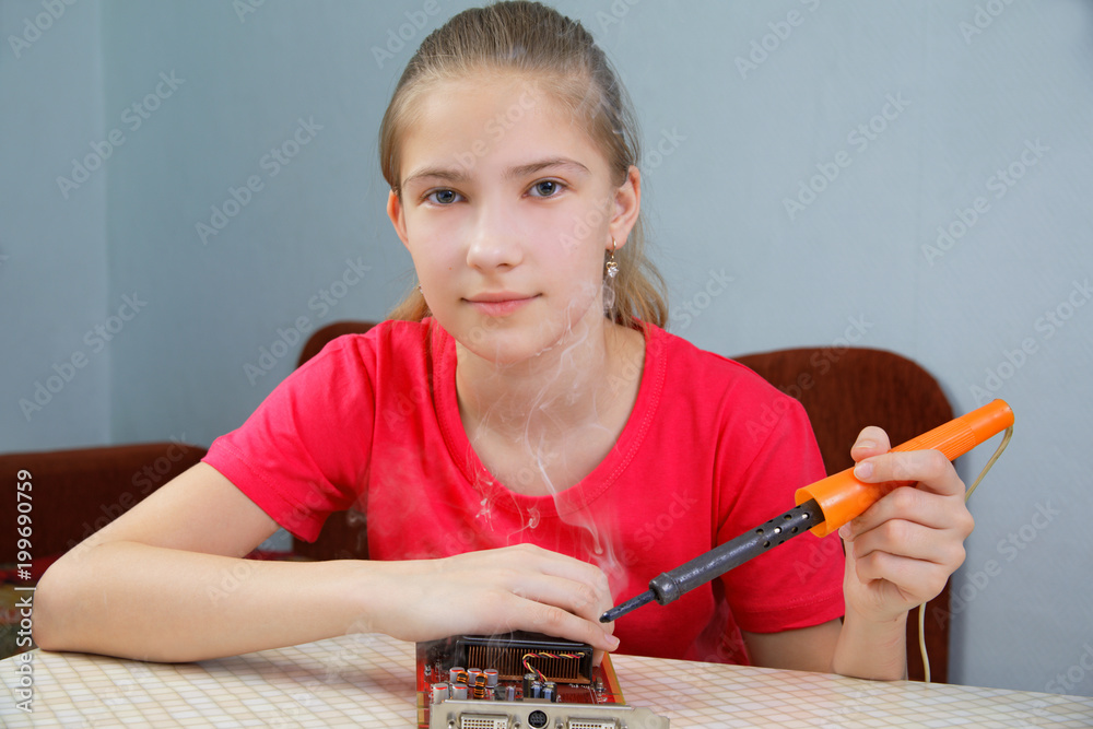 The girl learns to solder at home