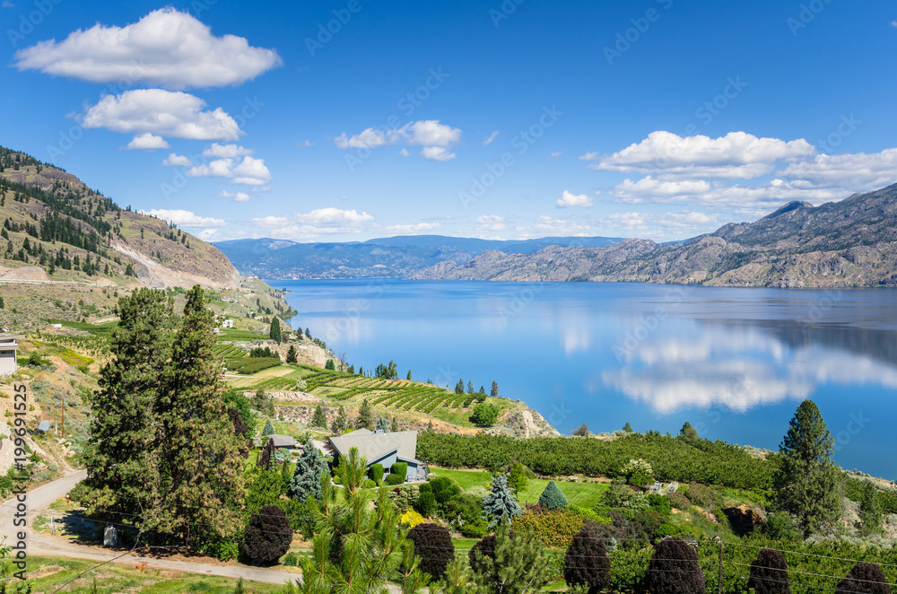 Obraz premium View of the Okanagan Lake under Blue Sky on a Sunny Summer Day and Reflection in Water. Penticton, BC, Canada.