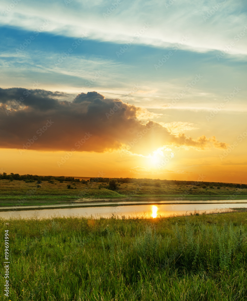orange sunset over green meadow and river - obrazy, fototapety, plakaty 