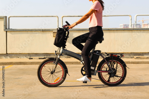 A young woman riding an electric bicycle