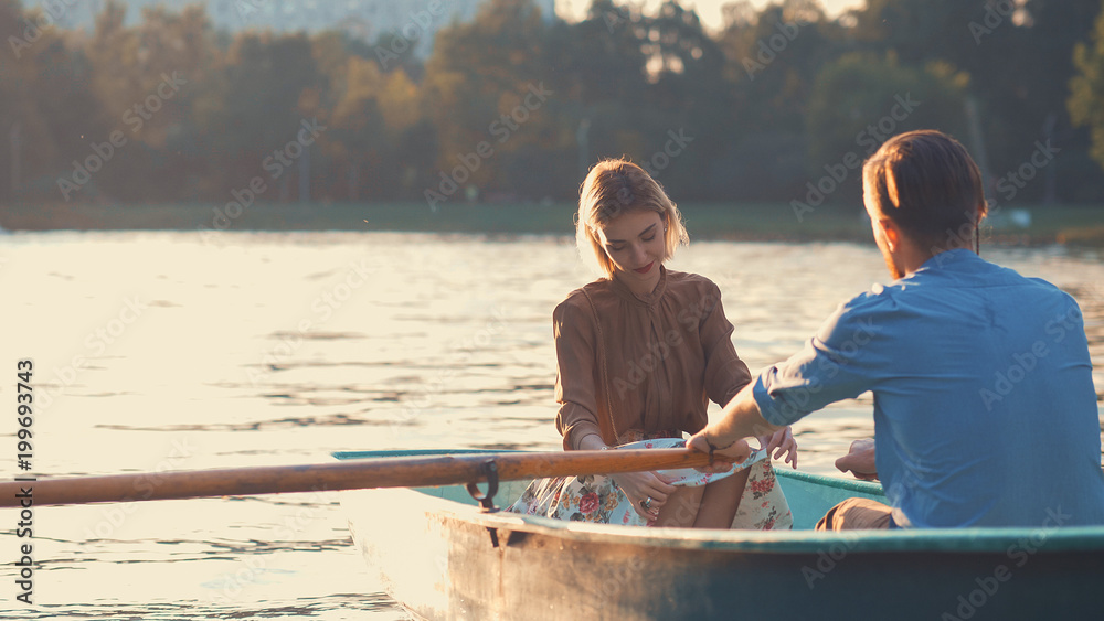 Young couple in a boat at sunset