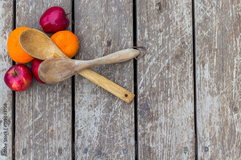 Woon and Bamboo spoons sit crossed on top of fruit on a barn wood surface. With room for text Woon and Bamboo spoons sit crossed on top of fruit on a barn wood surface. With room for text