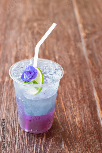 selective focus of Butterfly Pea soda drink on wooden table.