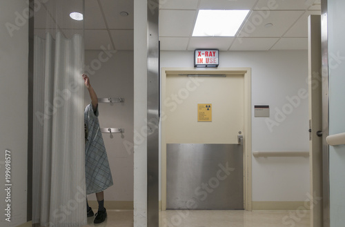 man behind curtain in examination changing room