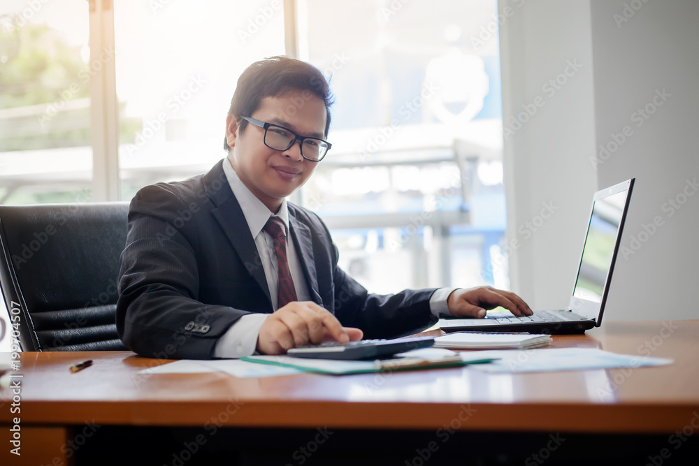 Business man working at office with laptop computer and documents financial reports Business man working at office with laptop computer and documents financial reports
