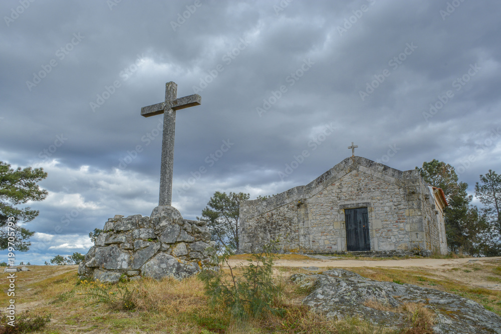 earlier stone cross with church on background earlier stone cross with church on background
