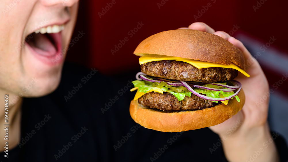 Process of eating delicious Burger served with beef, cheese and pickles in the cafe Process of eating delicious Burger served with beef, cheese and pickles in the cafe