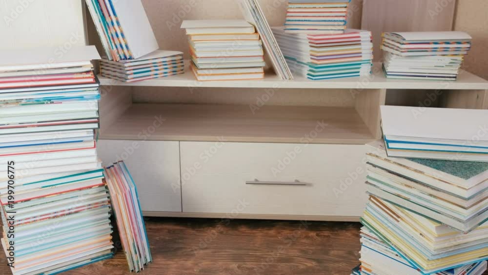 Pile of books on the floor and on the closet.