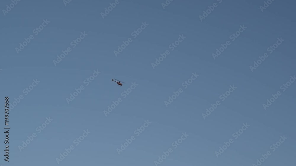 One helicopter flying in blue sky far off