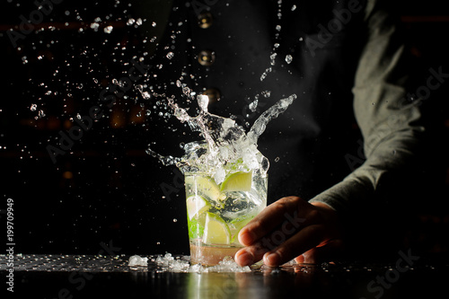 Cocktail splash with ice cubes and lime