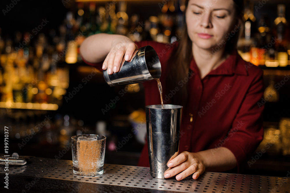Female bartender making cocktail at the bar counter