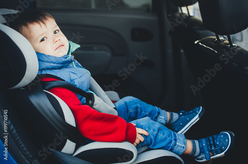 Adorable baby boy in safety car seat.