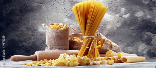 Various mix of pasta on grey rustic background. Diet and food concept.