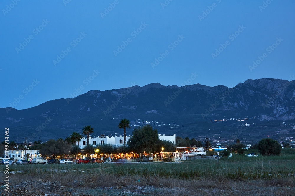Taverns on the street of a coastal town in the evening on the Greek island of Kos