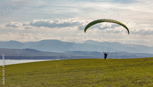Paraglider starts flight from the hill. Extreme sports activity.