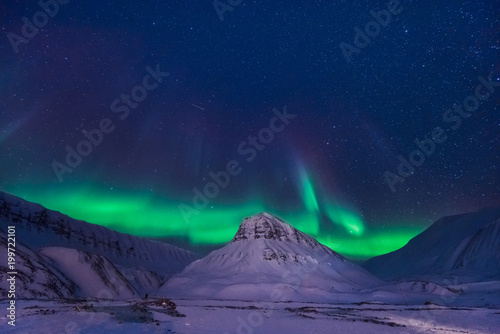 The polar arctic Northern lights aurora borealis sky star in Norway Svalbard in Longyearbyen city man mountains