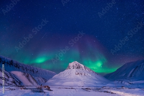 The polar arctic Northern lights aurora borealis sky star in Norway Svalbard in Longyearbyen city man mountains