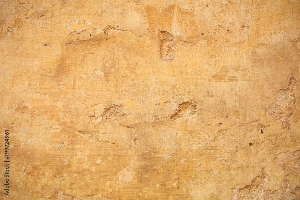 Weathered yellow painted wall background, partially faded Weathered yellow painted wall background, partially faded