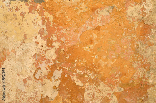 Detail of an old rough wall with orange color layers suitable as a background