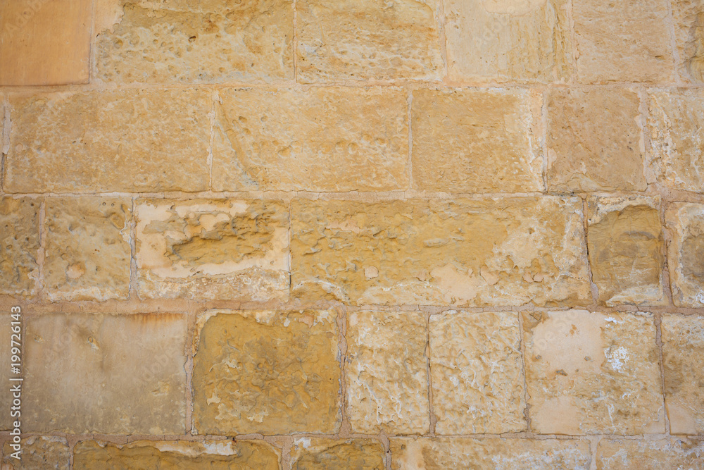 Traditional weathered stone wall background in Malta