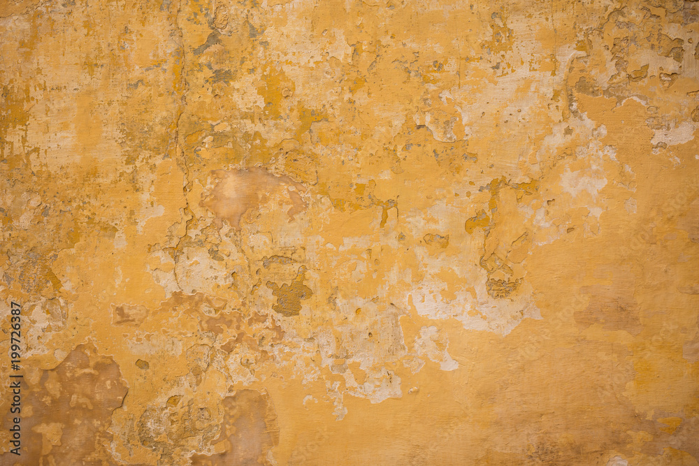 Weathered yellow painted wall background, partially faded