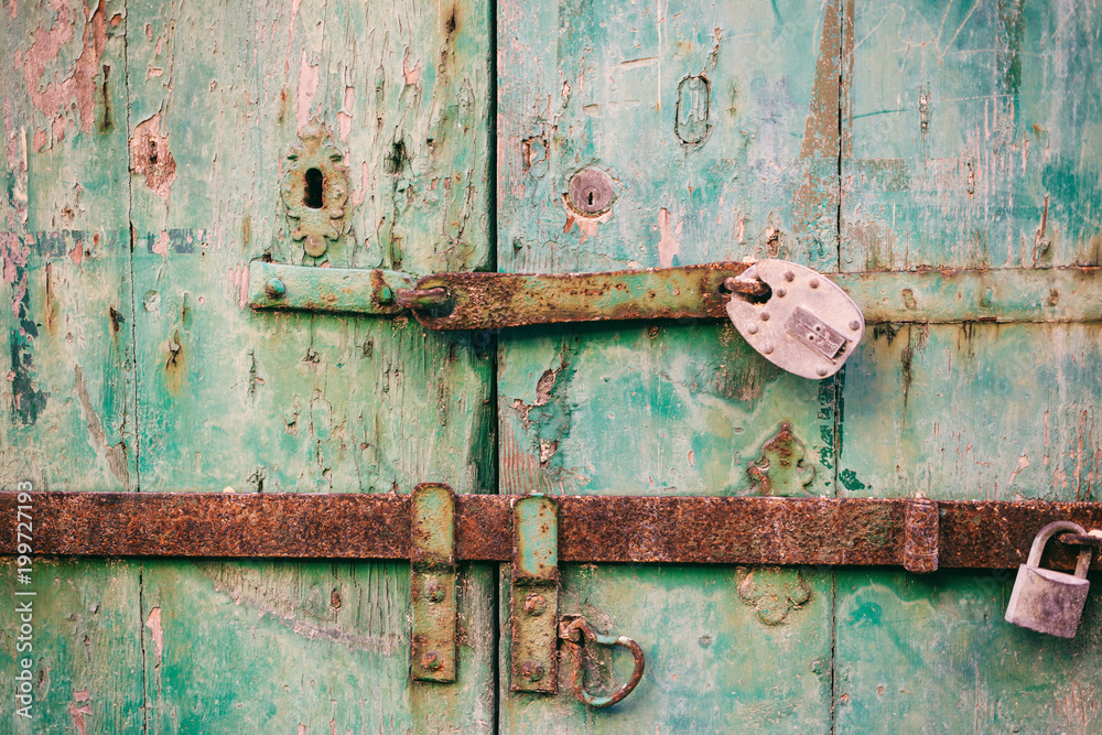 Locked door. Closed old rusty padlocks on a distressed wooden door Locked door. Closed old rusty padlocks on a distressed wooden door