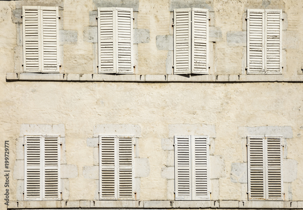 Naklejka premium house facade with eight closed shutters in white