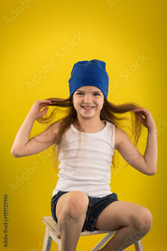 Beautiful caucasian girl posing in studio on a Yellow background