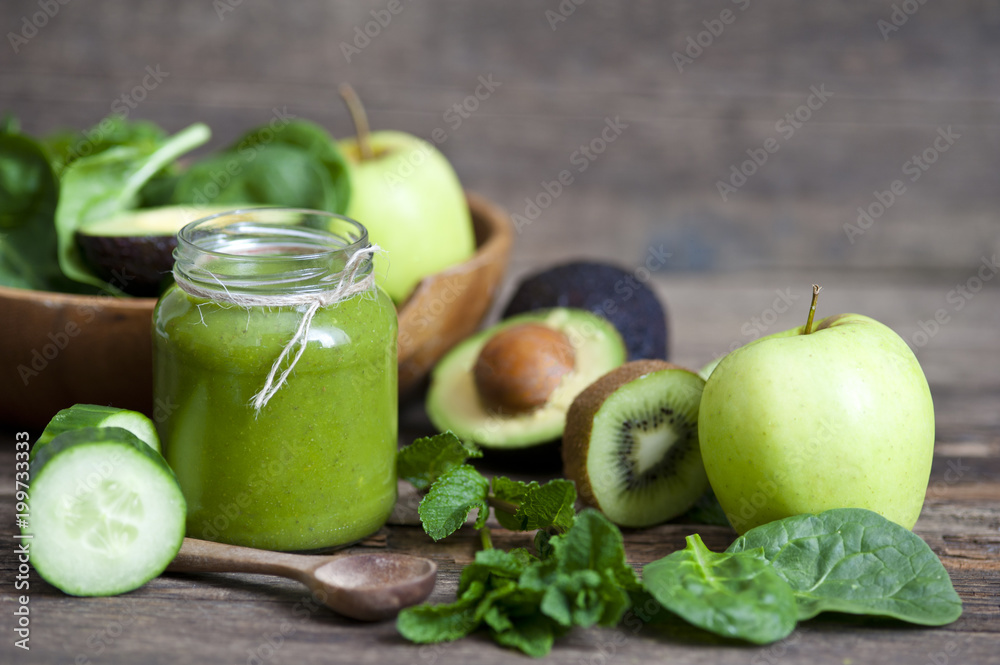 Healthy green smoothie with ingredients on wooden table Healthy green smoothie with ingredients on wooden table