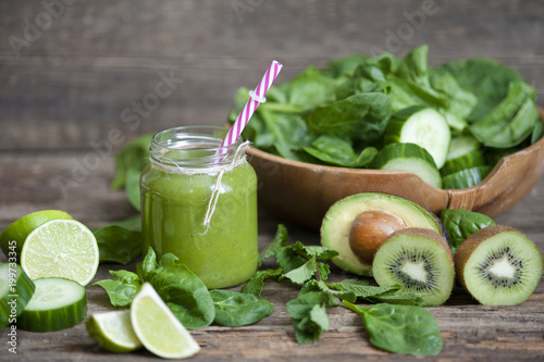  Healthy green smoothie with ingredients on wooden table 