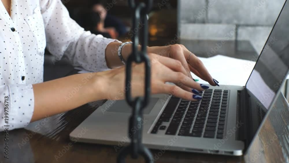 Positive formally dressed female journalist making distant job during work break in cafe interior