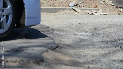 The car goes  a pothole. Wheels close up.
