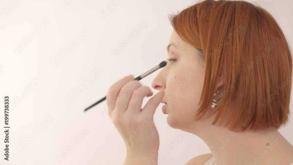 Portrait of young beautiful woman applies make up on lashes Portrait of young beautiful woman applies make up on lashes