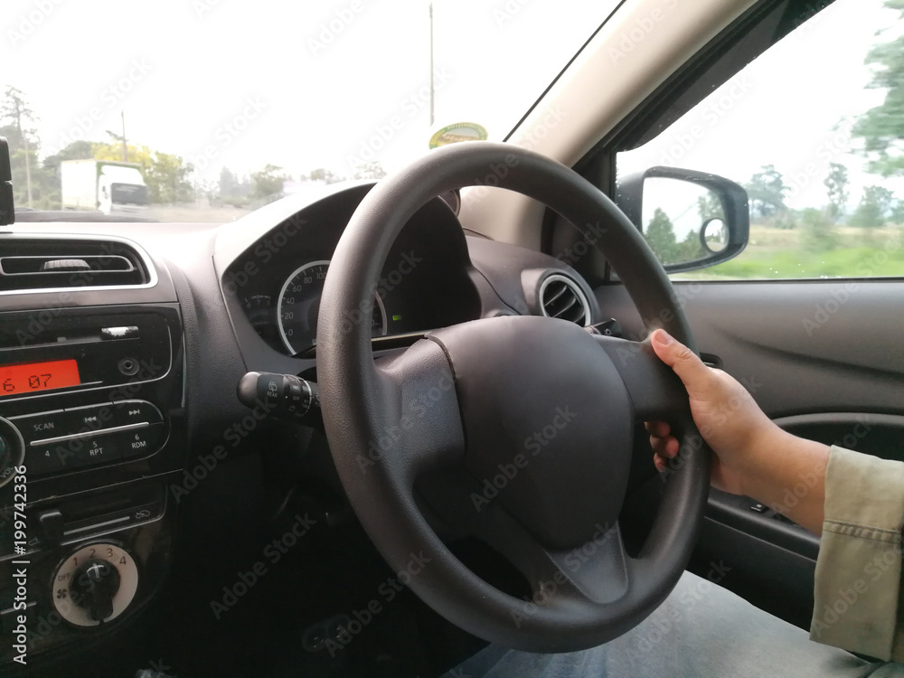 The man's one hand grips the steering wheel
