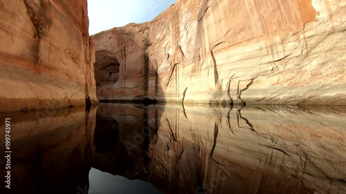 A beautiful clip of a perfect red sandstone reflection on Lake Powell. The water is calm and still with cliffs rising straight from the water. An amazing destination for fishermen, boaters and water s