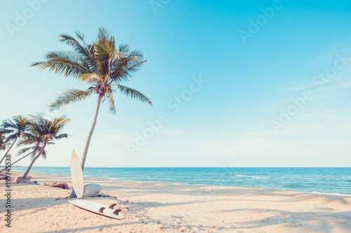 Fototapeta Naklejka Na Ścianę i Meble -  Vintage surf board with palm tree on tropical beach in summer. vintage color tone