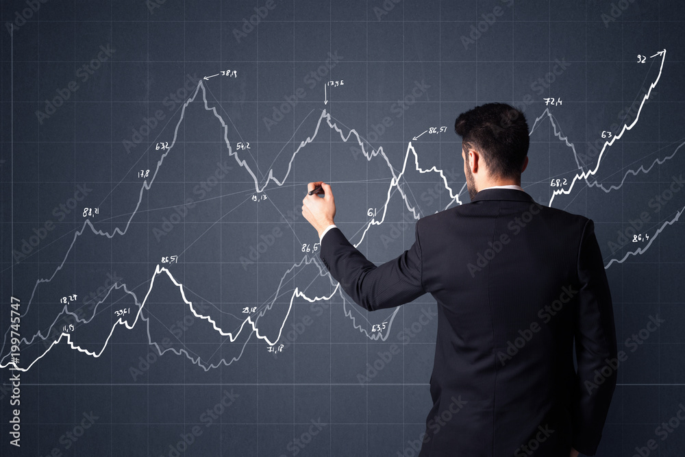 Young businessman in black suit standing in front of a progress chart Young businessman in black suit standing in front of a progress chart