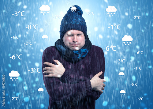 Young man freezing in warm clothing with weather condition and forecast concept
 photo