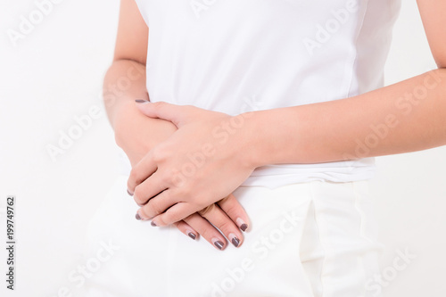 Pain in stomach. Beautiful young Asian woman feeling strong abdominal pain.  Isolated on white background. Studio lighting. Concept for healthy and medical © PRASERT