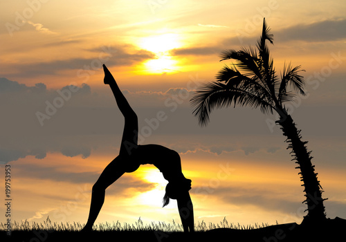 yoga among the palm trees at sunset