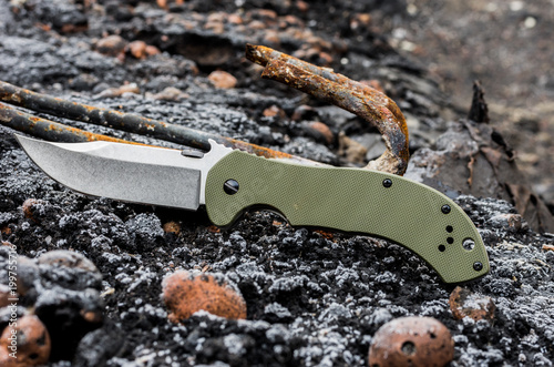 A military knife with an olive handle.