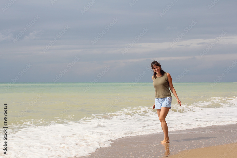 Beautiful girl in a t-shirt on the beach. Recreation Beautiful girl in a t-shirt on the beach. Recreation