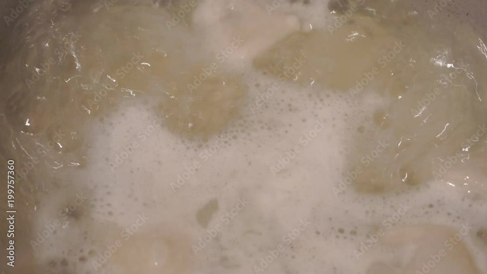 The soup broth is boiling in a small saucepan. Cooking dumplings. Close up The soup broth is boiling in a small saucepan. Cooking dumplings. Close up