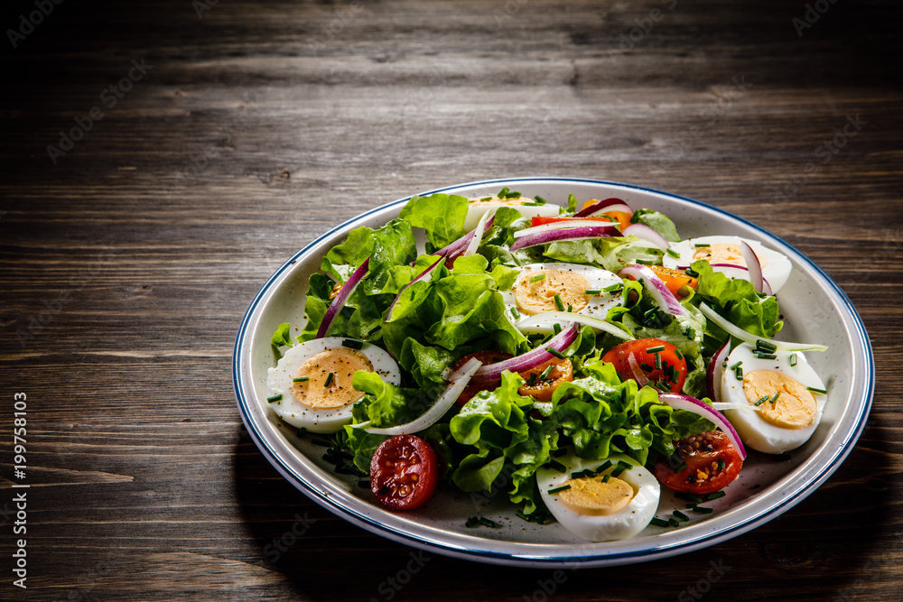 Boiled eggs and vegetables on wooden table Boiled eggs and vegetables on wooden table