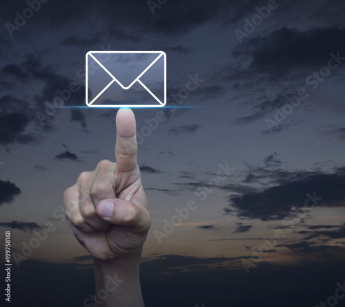 Hand pressing mail flat icon over sunset sky, Contact us concept