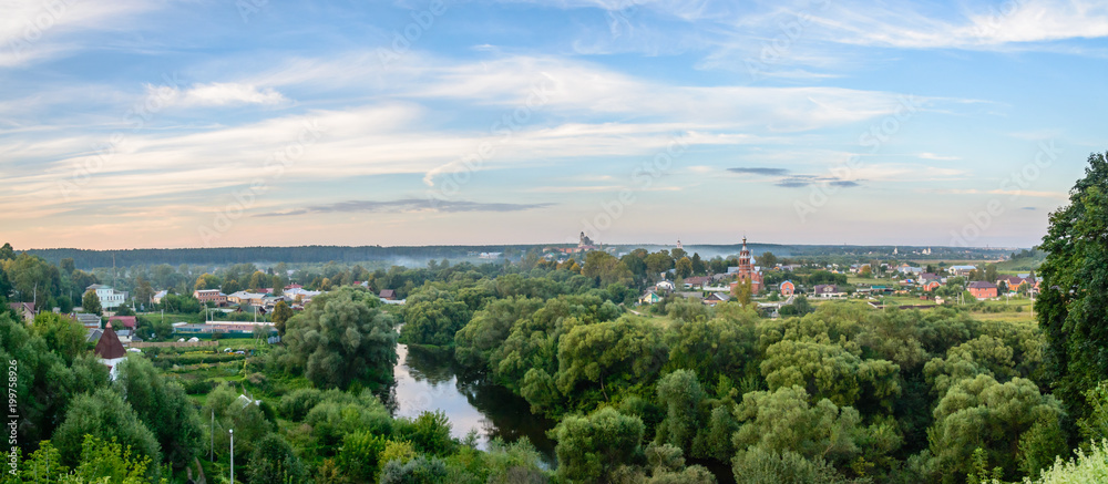 Evening panorama of Russian city with a river and churches