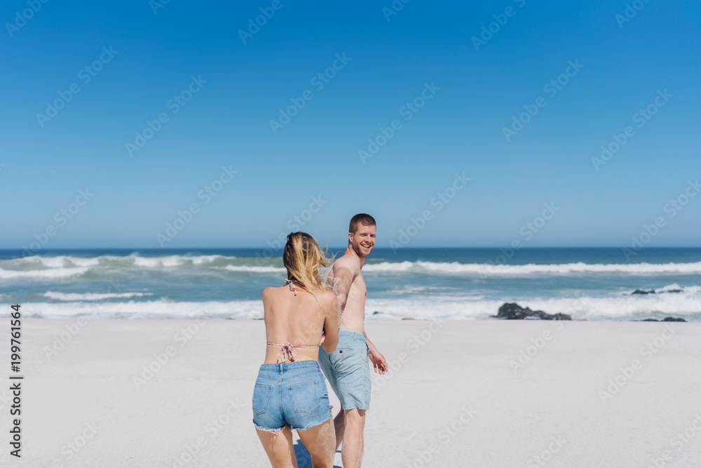 Young man pulling his girlfriend along behind him Young man pulling his girlfriend along behind him