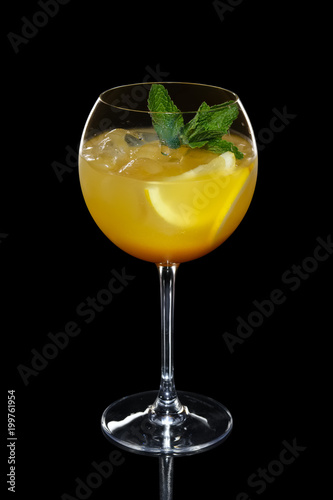 Cild lemon cocktail with a sparkling wine with ice in wine glass isolated on black